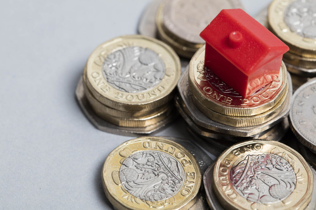 Housing cost. Red house with British currency